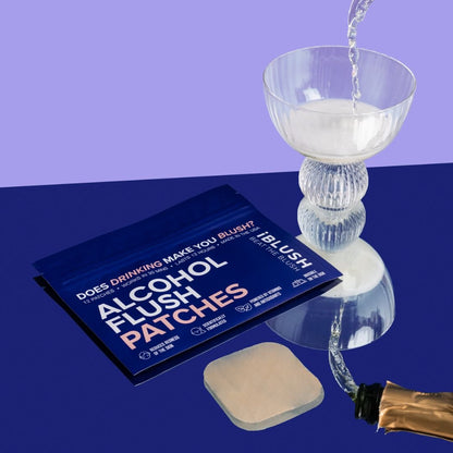 Asian flush patches with a glass of alcohol on a reflective surface